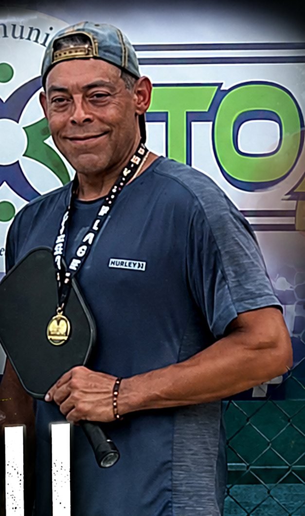 Sean O'Rourke holding a pickleball paddle and a medal